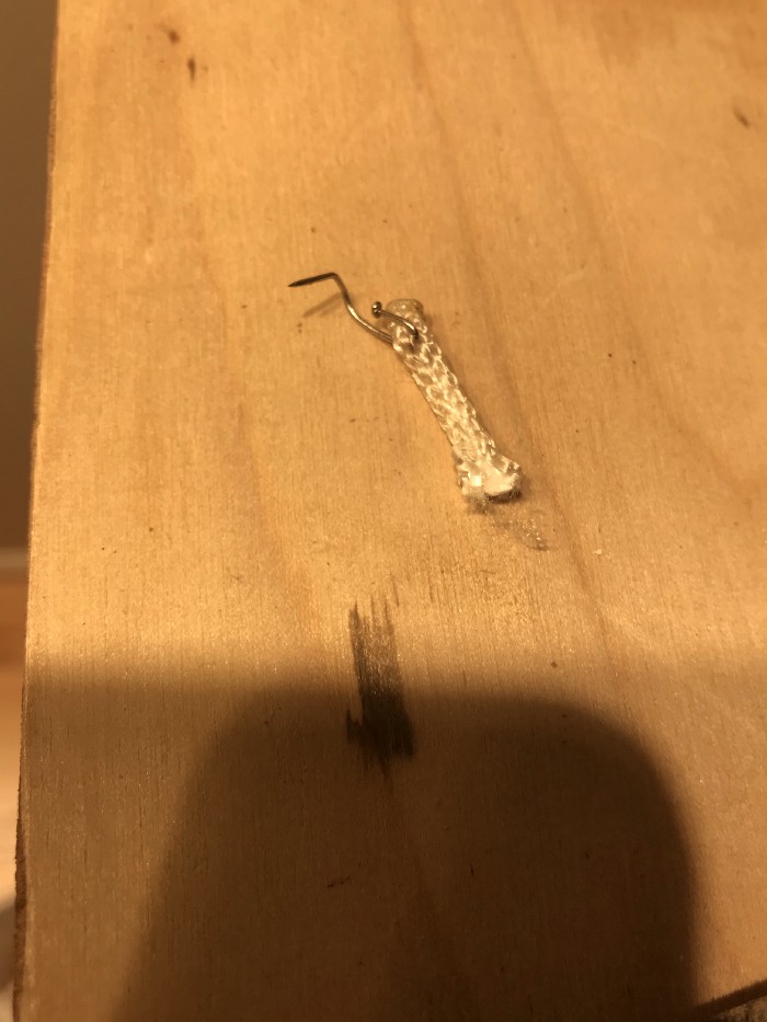 bent dressmaker's pin used as a staple in the end of a piece of paracord